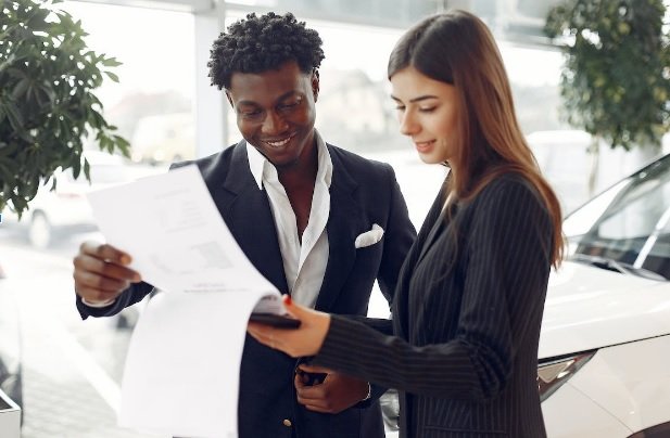 How To Find A Great Dealership If You Wish To Switch Cars 2 car sales rep looking at documents