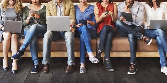 people reading news on laptop and mobile phones